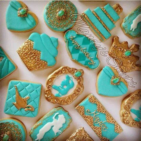 Cookies Decorated With Blue And Gold Icing Are Displayed On A White