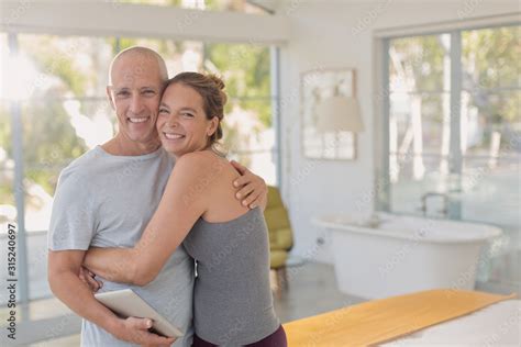 Portrait Happy Mature Couple With Digital Tablet Hugging In Bedroom Stock Photo Adobe Stock