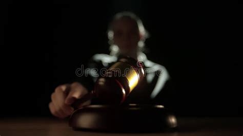 Female Sitting At The Desk With Wooden Hammer Dark Room Bright