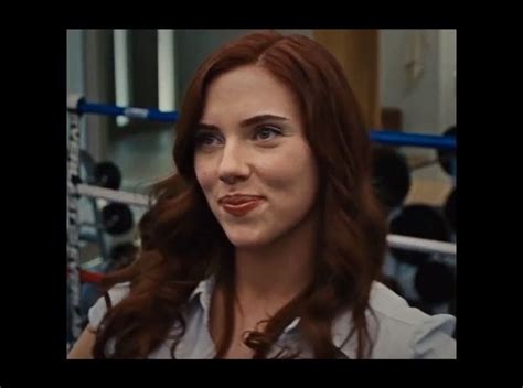 A Woman With Red Hair And Blue Eyes Is Standing In Front Of A Boxing Ring