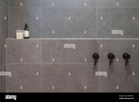 Tiled Bathroom Shower Area Showing Black Hot And Cold Taps Stock Photo Alamy