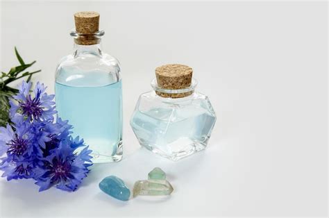 Botellas De Vidrio Con Agua De Flor De Aciano Azul O Aceite Sobre Fondo