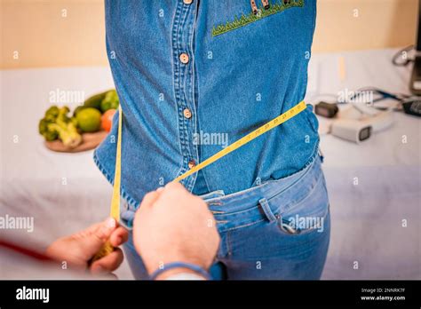 View Of A Male Nutritionist Measuring Female Patient Waist Concept Of