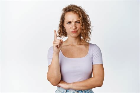 Fille blonde en colère aux cheveux courts fronçant les sourcils