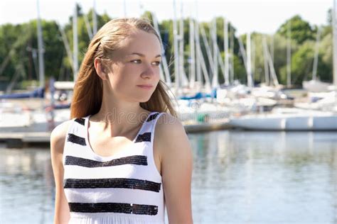 Attractive Model In Pink Bikini Sitting On Rocky Beach Stock Photo