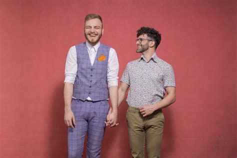 Smiling Two Men Gay Couple Leaning Back To Back Posing Looking To Camera Carefree Stock Photo