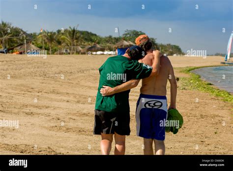 Two Gay Men Walking Along Beach With Arms Around Each Other Stock Photo Alamy