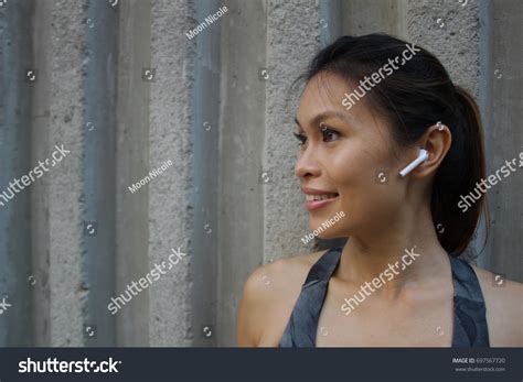 Beautiful Asian Female Wearing Air Pods Stock Photo 697567720