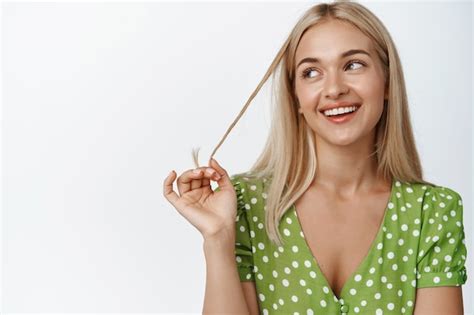 Belle Fille Blonde En Robe Jouant Avec Les Cheveux Et Souriant L Air Pensif Debout Sur Blanc
