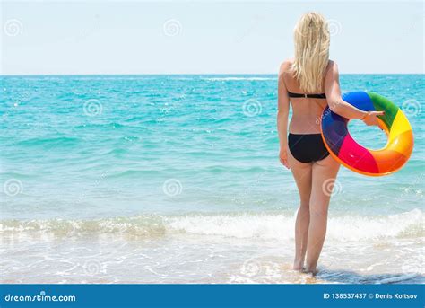 Una Festa Della Spiaggia La Bella Donna Sexy In Bikini Con Il Cerchio Gonfiabile Guarda Fuori Al