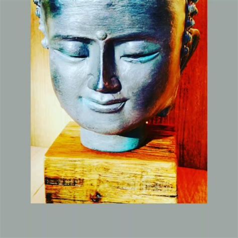 A Buddha Head Sitting On Top Of A Wooden Block