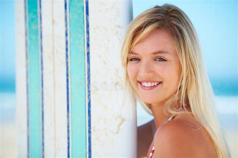 Enjoying The Moment Portrait Of A Pretty Blonde With Her Surfboard On The Beach Stock Image