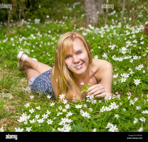 Junge hübsche blonde Frau auf einer Wiese mit Blumen Stockfotografie Alamy
