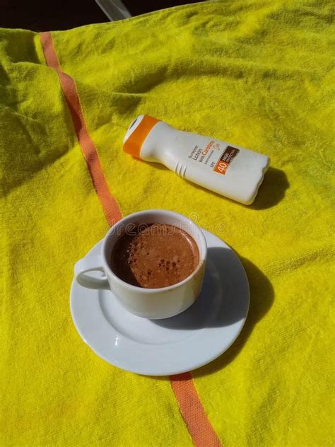 Enjoying And Relaxing On The Beach With A Cup Of Hot Chocolate And Suntan Lotion Stock Image