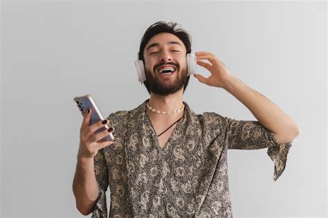Queer latino gay olhando para a câmera enquanto ouve música através de seus fones de ouvido em