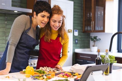 Premium Photo Happy Biracial Lesbian Couple Preparing Vegetables Using Tablet In Kitchen Copy