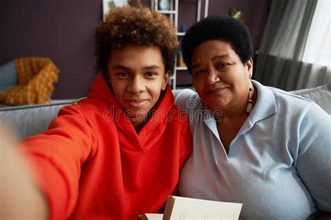 Affectionate Mature Woman And Her Teenage Son Taking Selfie At Home Stock Photo Image Of Woman