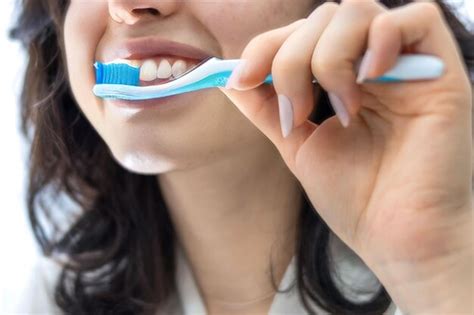 Retrato de una joven latina irreconocible cepillándose los dientes en el baño de casa realizar