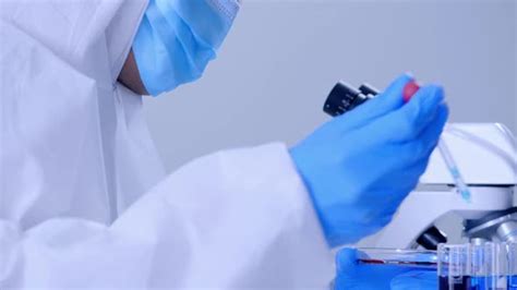 Scientist In Ppe Suite Doing Some Research Checking A Liquid In A Test