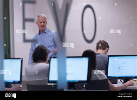 Handsome Mature Teacher And Students In Computer Lab Classroom Stock Photo Alamy