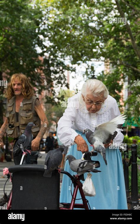 Woman elderly feeding pigeons park Stock Photo - Alamy