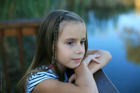 Pretty Girl Looking Out Over A Pond On An Autumn Evening By Stocksy