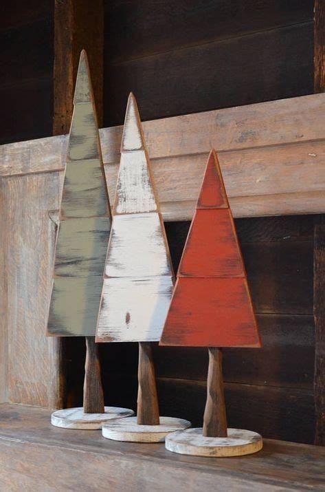 Three Wooden Christmas Trees Sitting On Top Of A Mantle