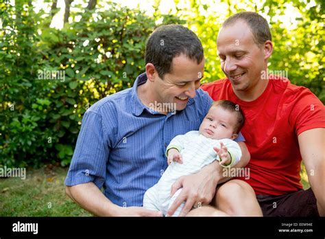 Caucasian Gay Couple Smiling With Baby Boy In Backyard Stock Photo Alamy