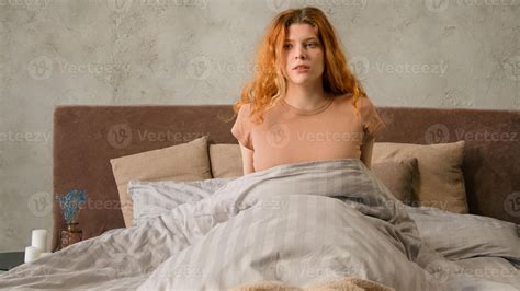 Caucasian woman suddenly wake up on bed in morning in bedroom student