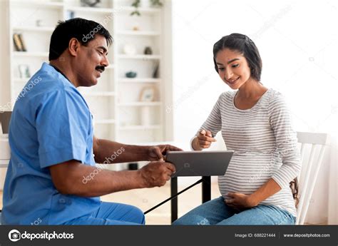 Smiling Mature Doctor Showing Digital Tablet Test Results Pregnant