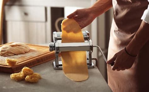 Premium Photo | Man using pasta machine to prepare dough for