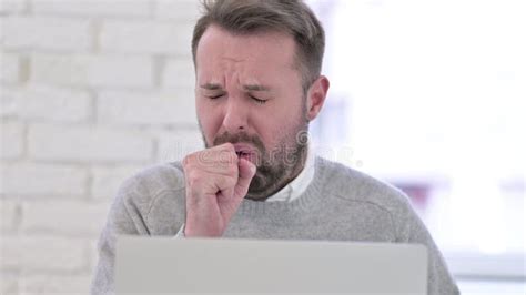 close   sick man coughing  working  desktop stock photo