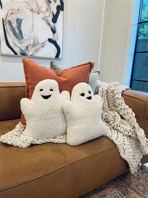 Two Ghost Pillows Sitting On Top Of A Couch