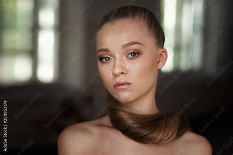Beautiful Woman With Long Blonde Hair With Nude Make Up And Bare Shoulders Posing In Studio With