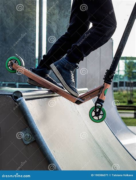 Teenager Boy Rides on Kick Scooter in Outdoor Skatepark. Summer Extreme