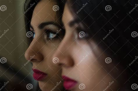 Young Charming Brunette Girl Looks At Her Reflection In The Mirror