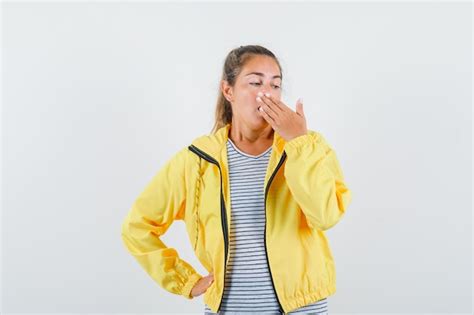 Femme Blonde Couvrant La Bouche Avec Les Mains En Blouson Aviateur