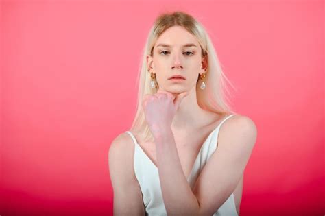 Joven gay de 20 años con maquillaje aislado en un retrato de estudio de fondo coloreado gente