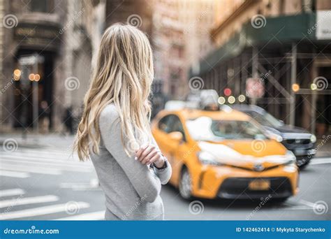 Blonde Woman Standing On City Street And Waiting For Taxi Car At Sunny Day Stock Photo Image