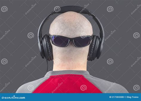 Back Of A Naked Man Listening To Music With Headphones And Sunglasses On The Back Of His Stock