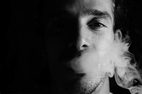 Premium Photo Close Up Portrait Of Man Smoking Against Black Background