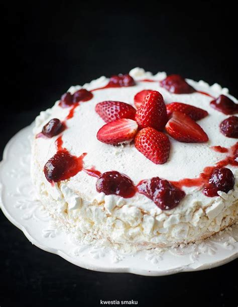 A White Cake With Strawberries On Top And Whipped Cream Around The