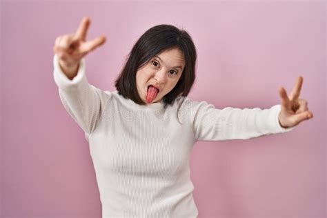 Woman With Down Syndrome Standing Over Pink Background Smiling With