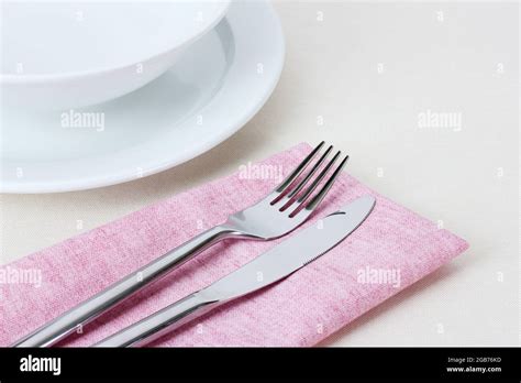 Table setting with fork, knife, plates and napkin Stock Photo - Alamy