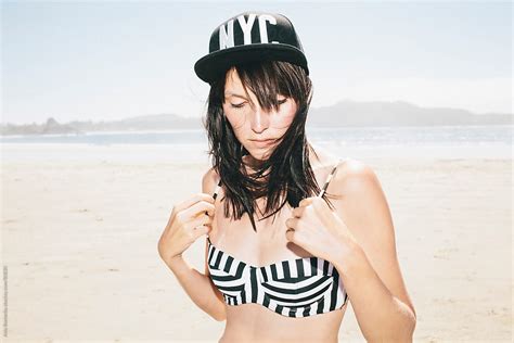 A Beautiful Brunette Adjusting Her Bikini On A Beach By Stocksy Contributor A Model