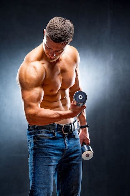 Premium Photo Male Athlete Bodybuilder Holds Dumbbell In Hand Pumping Muscles Naked Torso