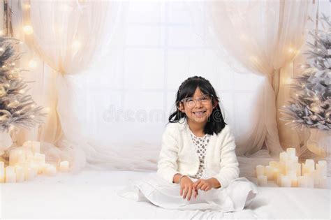 5 Year Old Latina Girl With Eyeglasses Among Decorated Trees Is Excited To Celebrate Christmas