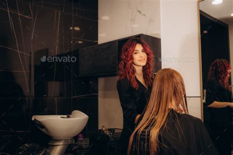 Pretty Brunette Working As Hairdresser And Cutting Hair Tips Of A Female Customer In A Beauty
