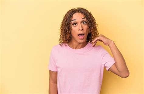 Jovem Mulher Transexual Latina Isolada Em Fundo Amarelo Rindo De Algo Cobrindo A Boca As