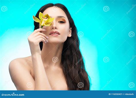 Uma Menina Moreno Bonita Dos Ombros Do Nude Guarda Sensualmente Um Flowe Imagem De Stock